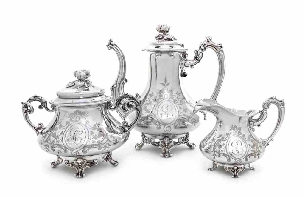 A French Silver Three-Piece Tea Set, Alphonse Debain,: A French Silver Three-Piece Tea Set, Alphonse Debain, Paris, Circa 1915, comprising a teapot, creamer and covered sugar bowl, all of squat baluster form, engraved with oval strapwork cartouches enclos