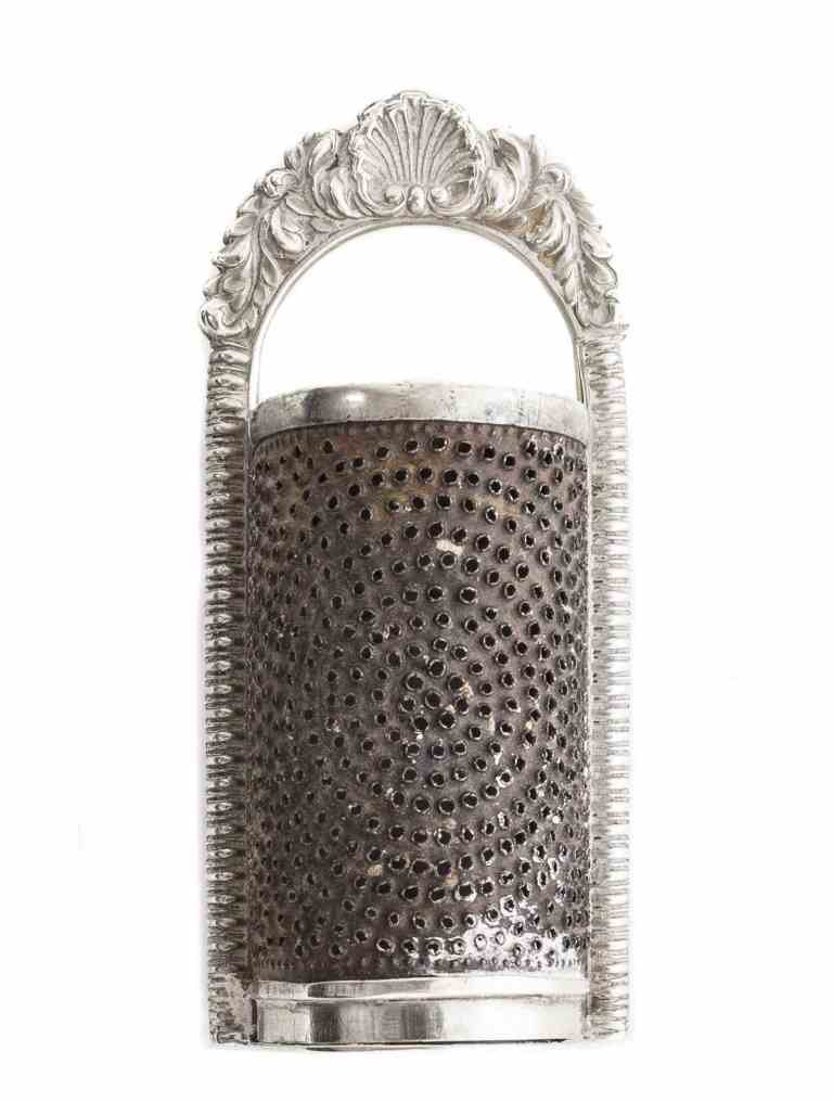 A George IV Silver Nutmeg Grater, Mary Ann and Charles: A George IV Silver Nutmeg Grater, Mary Ann and Charles Reilly, London, 1827, with gadrooned edges and flat hinged cover, the loop handle cast with a shell flanked by acanthus, reverse engraved "SHC to