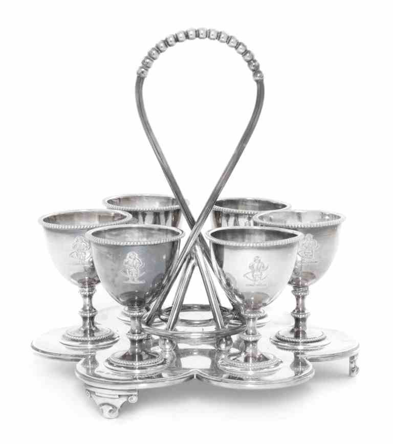 A Victorian Silver Egg Cruet, William Padley & Son,: A Victorian Silver Egg Cruet, William Padley & Son, Sheffield, 1875, of hexafoil form, raised on bracket feet, centered by a beaded loop handle, detachable cups with beeded borders, center of frame an