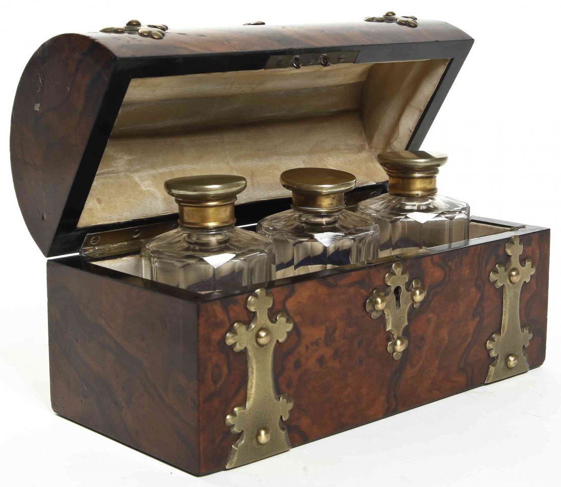 A Victorian Brass Banded Burlwood Scent Casket, Width 7: A Victorian Brass Banded Burlwood Scent Casket, the domed hinged lid opening to three faceted bottles, each with a brass cap and a glass stopper. Width 7 3/8 inches. Property from the Collection of Da