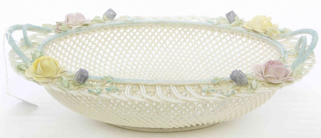A Belleek Oval Basket, Width 12 1/2 inches.: A Belleek Oval Basket, 1921-present, modeled with twig handles and applied tinted flowers, having Belleek (R) and Co. Fermanagh pad marks to base. Width 12 1/2 inches. Property from a Midwest Family C