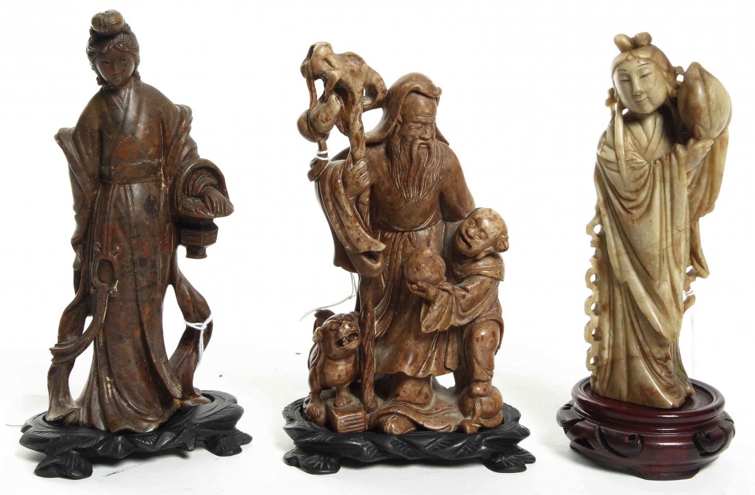 Three Carved Soapstone Figures, Height of first 6: Three Carved Soapstone Figures, the first depicting a lady with a coiled coiffure, standing in draped robes, the second depicting Shoulao with his craggy staff, a young boy at his side and presenting 