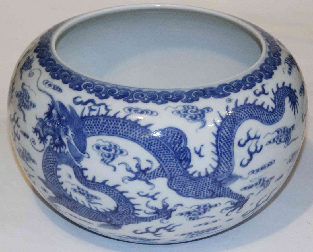 A Blue and White Porcelain Bowl, Diameter 10 inches.: A Blue and White Porcelain Bowl, of bulbous form, depicting five-claw dragons pursuing a flaming pearl beneath a repeating ruyi border and above crashing waves, bearing Kangxi mark within a double rin