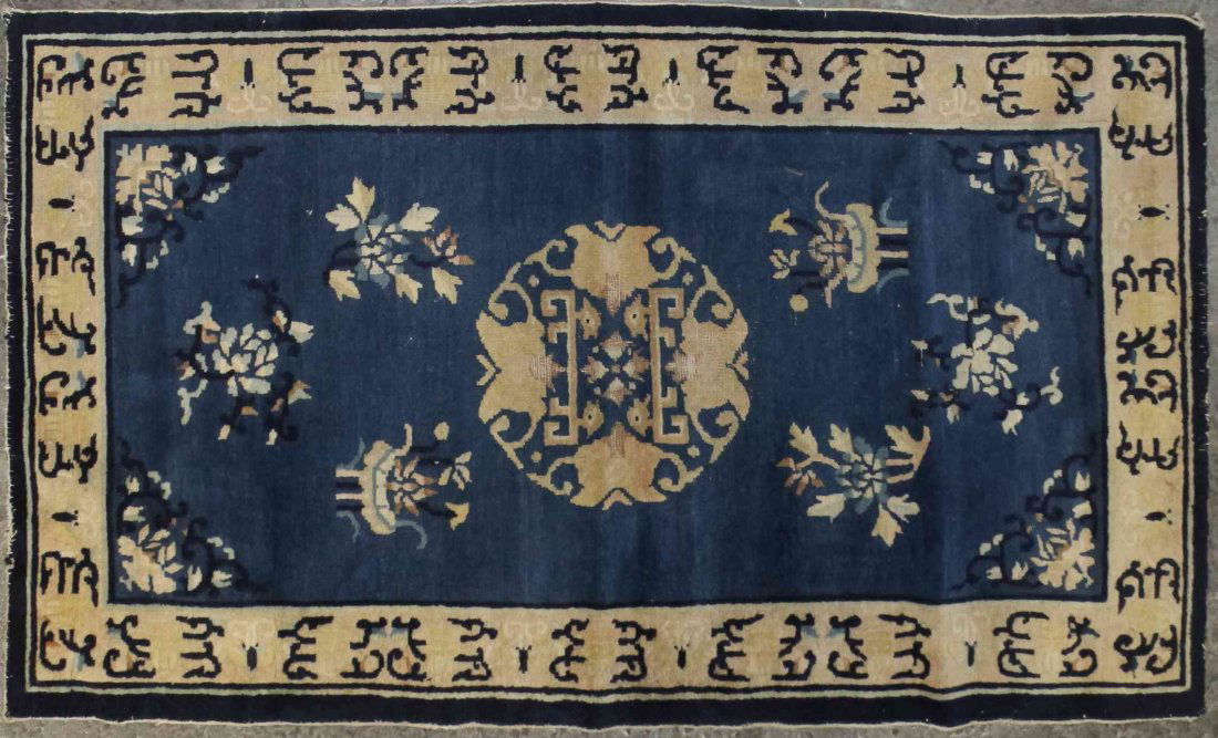 A Chinese Wool Rug, 4 feet 2 inches x 2 feet 6 inches.: A Chinese Wool Rug, centered with a foliate and character medallion on a blue field within a single border. 4 feet 2 inches x 2 feet 6 inches. Property from the Collection of Dan Johnson, Chicago, Ill