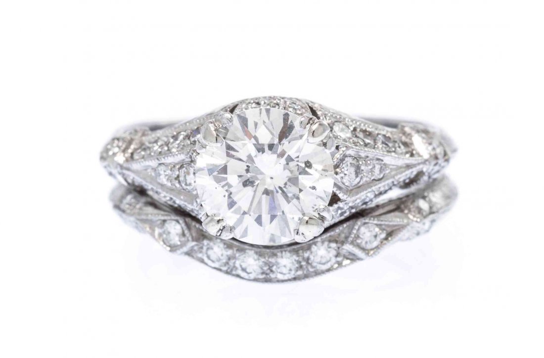 A Platinum and Diamond Ring, 5.40 dwts.: A Platinum and Diamond Ring, in an Art Deco style with millegrain accents and hand engraved detail, containing one round brilliant cut diamond weighing approximately 1.72 carat and 38 round brilliant 