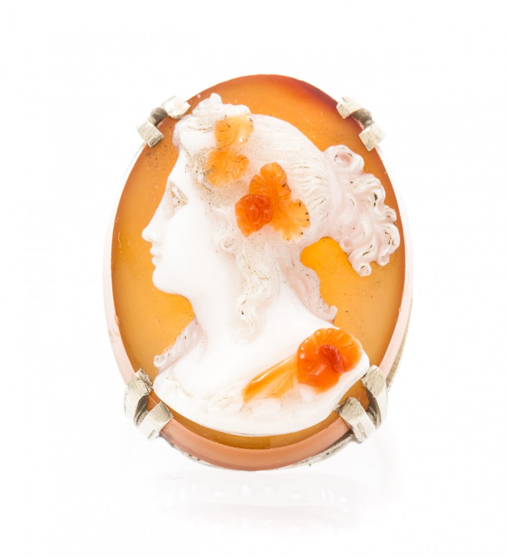 A 14 Karat White Gold and Agate Cameo Ring, 5.40 dwts.: A 14 Karat White Gold and Agate Cameo Ring, consisting of one oval agate cameo depicting a Classical female profile measuring approximately 24.00 x 18.50 mm in a filigree setting. 5.40 dwts.