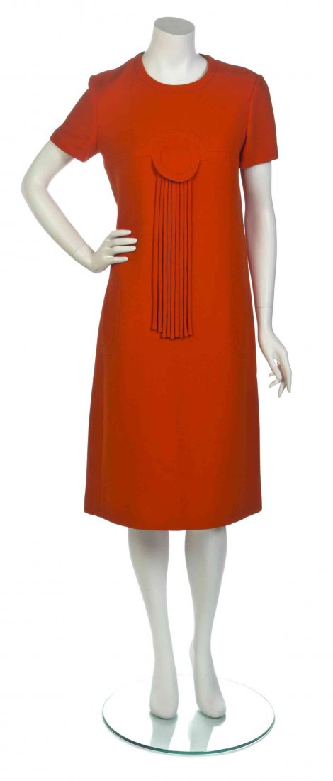 A Pierre Cardin Orange Dress,: A Pierre Cardin Orange Dress, short sleeves with a jewel collar, side seam pockets and a fringe trim disc applique to the bustline. Labeled within lining: Pierre Cardin. Property from the collection o