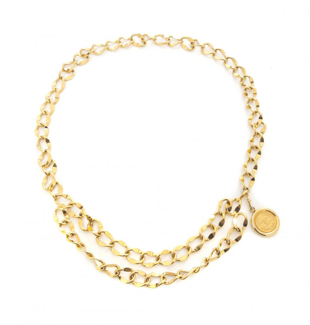A Chanel Goldtone Chain Belt,: A Chanel Goldtone Chain Belt, with a double chain swaggering at the front and a single coin medallion stamped: Chanel 31 Rue Cambon Paris.