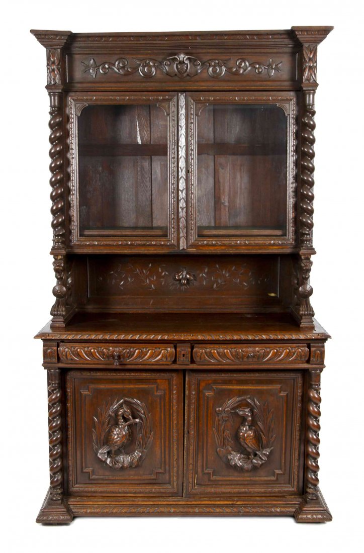 A Renaissance Revival Carved Walnut Buffet, Height 94: A Renaissance Revival Carved Walnut Buffet, late 19th century, in two parts, the upper section with flat cornice over two glazed doors flanked by spiraled columns, raised on recumbant griffin supports