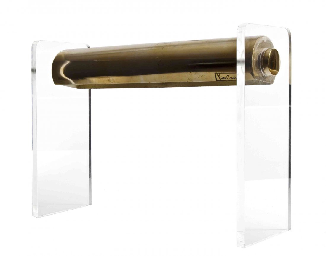 A Pierre Cardin Desk Lamp, Height 12 x width 17 inches.: A Pierre Cardin Desk Lamp, circa 1970s/80s, with horizontal cylindrical goldtone metal shade raised on lucite uprights, with Pierre Cardin label. Height 12 x width 17 inches.