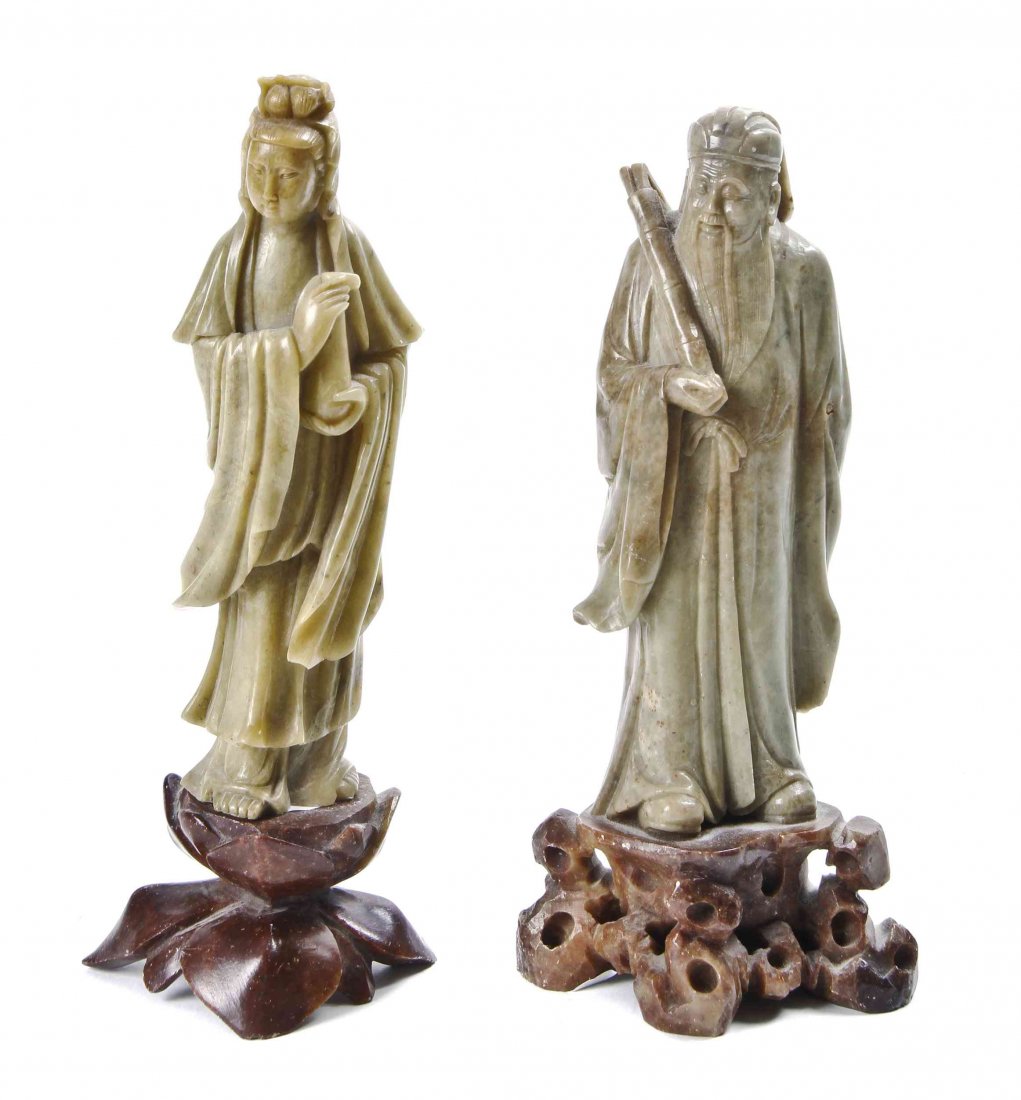A Pair of Asian Export Stone Carvings of Figures,: A Pair of Asian Export Stone Carvings of Figures, in pale green stone, possibly soapstone, depicting a female deity, and a scholar, both with carved red stone stands. Height of tallest 7 3/4 inches.