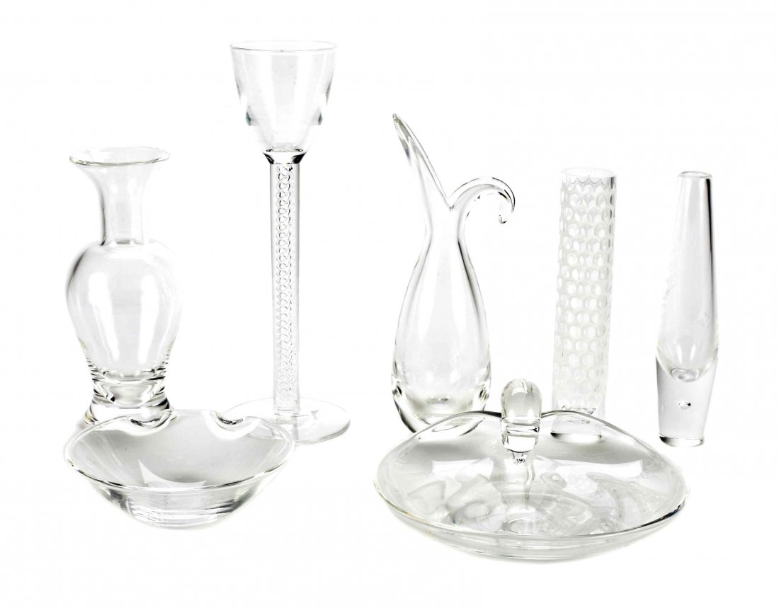 A Collection of Steuben Glass Table Articles, Height of: A Collection of Steuben Glass Table Articles, comprising three vases, a stem, a pitcher, an ash receiver and a covered dish, etched Steuben. Height of tallest 12 inches. Property from a Distinguished 