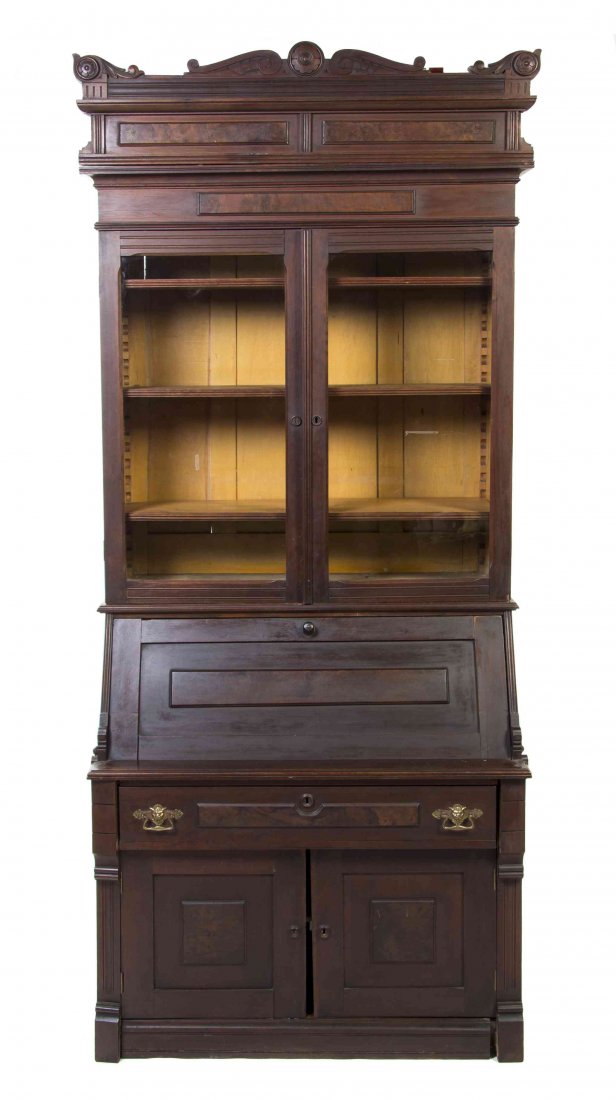An American Walnut Secretary Bookcase, Height 93 x: An American Walnut Secretary Bookcase, in two parts, the superstructure having a shaped floral decorated cornice over two glazed doors, opening to a shelved interior, the base set with a fall front wr