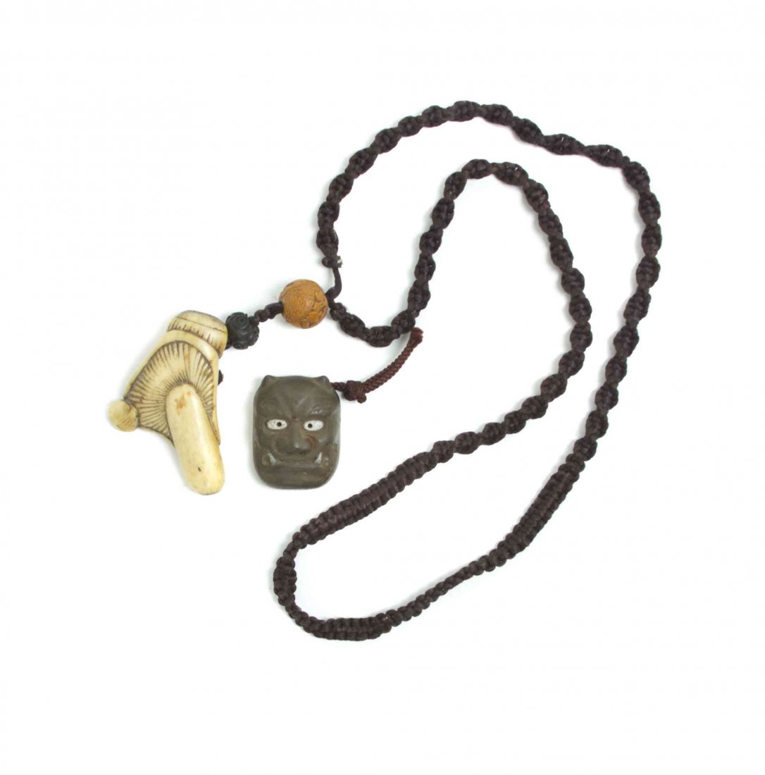 A Bone Mushroom Netsuke, Height of first 2 7/8 inches.: A Bone Mushroom Netsuke, together with an oni mask on silk cord, with boxwood carved ojime of a treasure boat. Height of first 2 7/8 inches. Property from the Collection of Dr. J. Don Nelson, Fargo, N