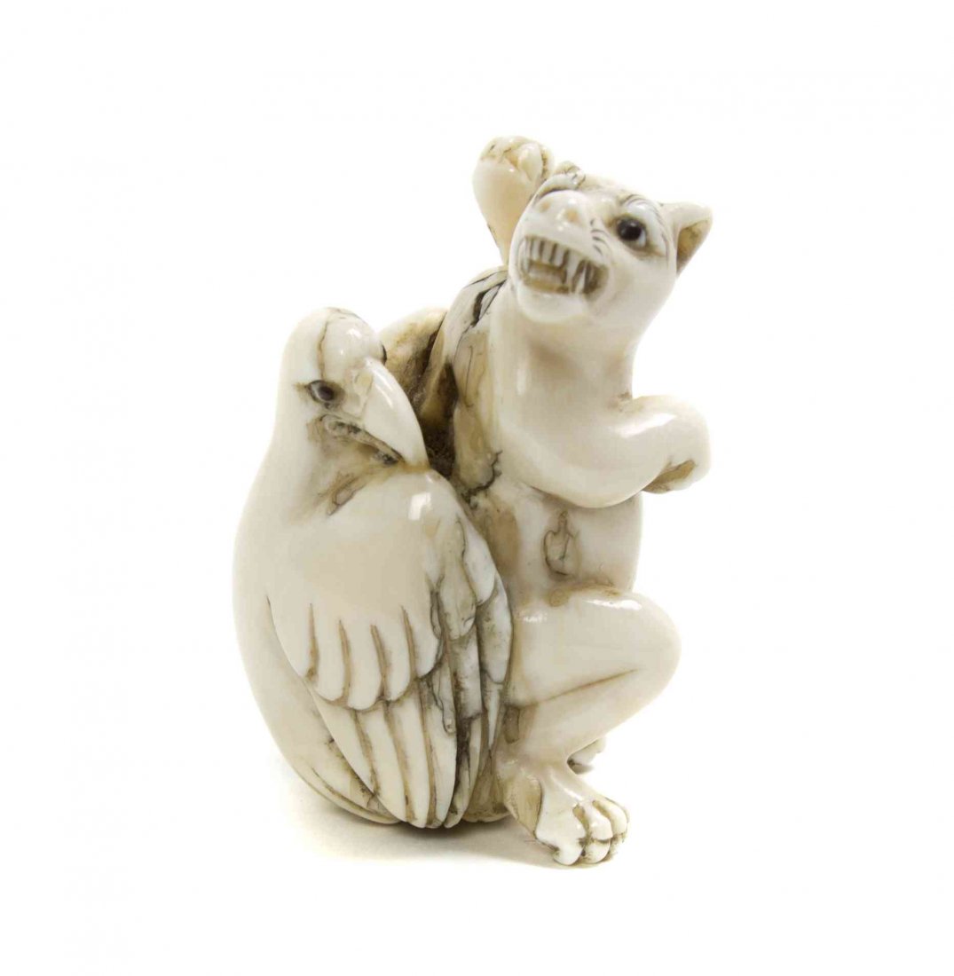 A Carved Ivory Netsuke, Height 2 1/2 inches.: A Carved Ivory Netsuke, depicting a struggle between an eagle and a wolf, each with inlaid eyes. Height 2 1/2 inches. Property from the Collection of Dr. J. Don Nelson, Fargo, North Dakota Provenance: