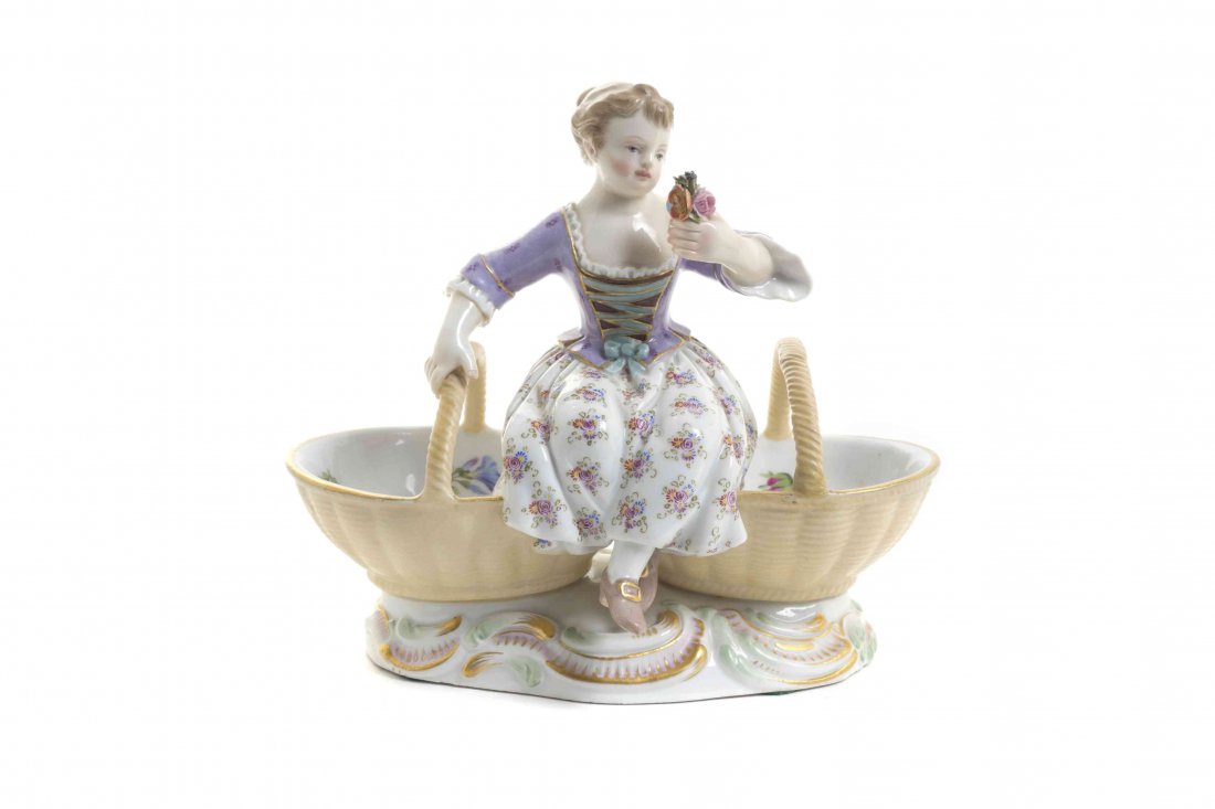 A Meissen Porcelain Figural Double Salt, Width 5 3/4: A Meissen Porcelain Figural Double Salt, in the form of a seated girl between two basket form cellars, having crossed swords in underglaze blue, incised 3024, impressed 63. Width 5 3/4 inches. Propert