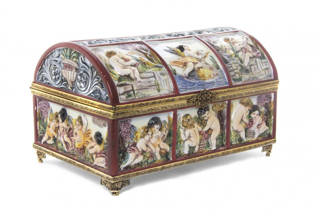 A Capodimonte Porcelain Music Box, Width 10 inches.: A Capodimonte Porcelain Music Box, modern, of rectangular form with domed lid decorated with carious scenes of putti in relief, having cylinder music box mechanism to interior. Width 10 inches. Proper