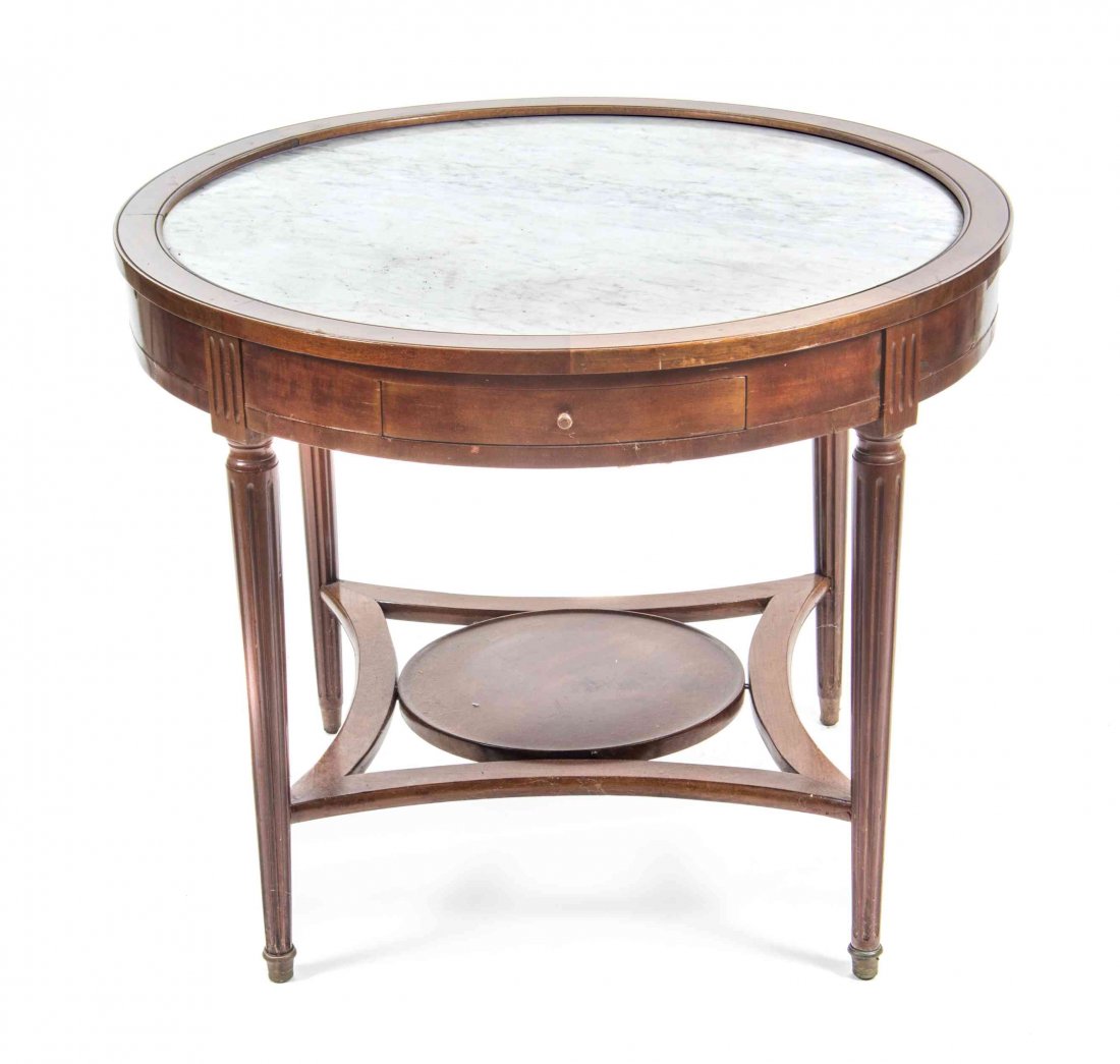 A Louis XVI Style Mahogany Gueridon, Height 28 3/8 x: A Louis XVI Style Mahogany Gueridon, having a circular marble-inset top above a frieze drawer and candle slides, raised on fluted legs joined by a medial shelf. Height 28 3/8 x diameter of top 35 1/8 