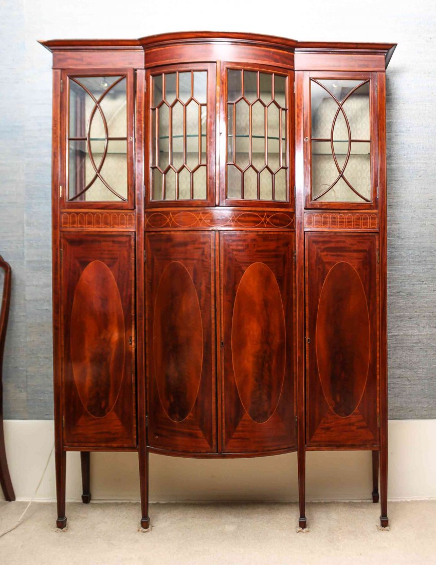 An Edwardian Mahogany Breakfront Display Cabinet,: An Edwardian Mahogany Breakfront Display Cabinet, the rectangular top with central convex section over the conforming case fit with four glazed doors and two paneled doors, the whole raised on square 