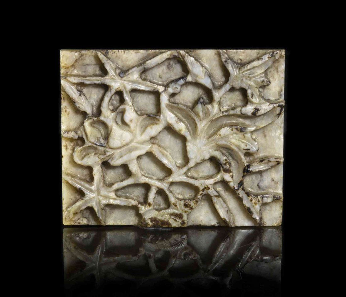A Chicken Bone Jade Plaque, Width 3 3/16 inches.: A Chicken Bone Jade Plaque, late Ming Dynasty, of squared form having relief carved floral decoration. Width 3 3/16 inches.