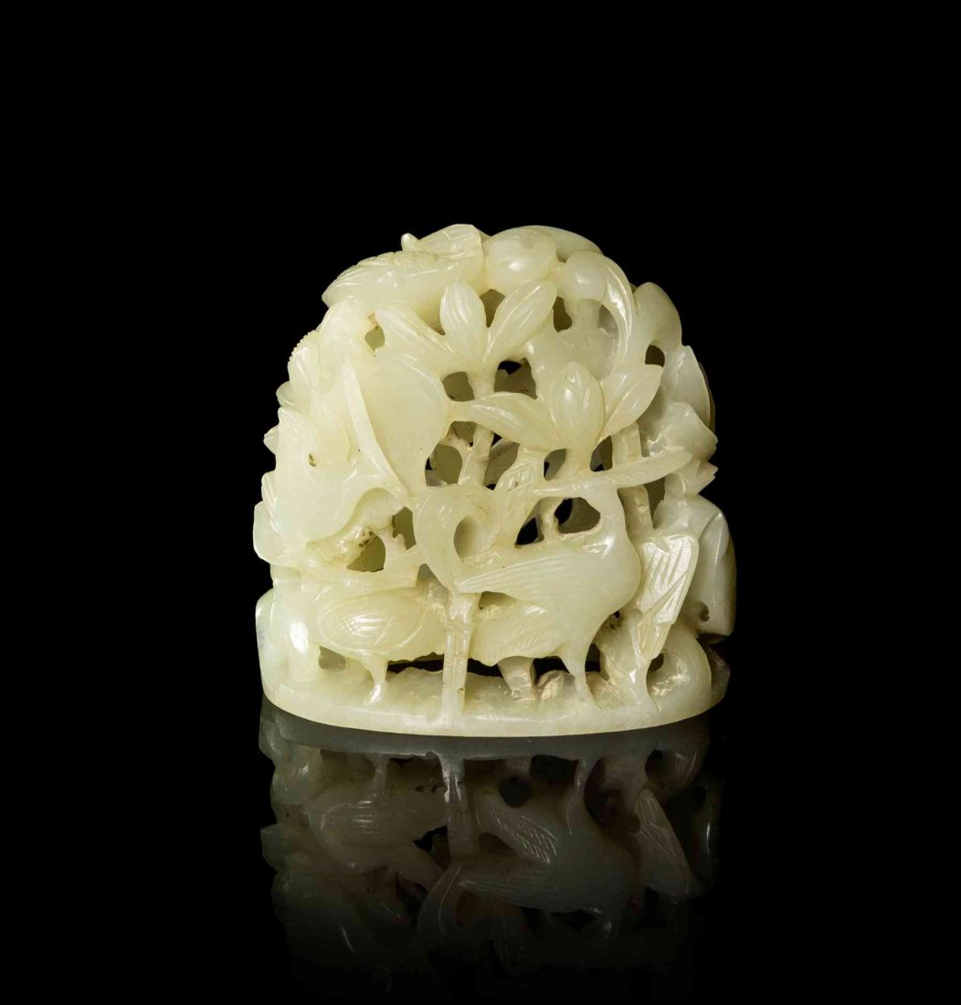 A Carved White Jade Hat Finial, Height 2 3/8 inches.: A Carved White Jade Hat Finial, of domed form depicting cranes below canopies of flowers and leaves, on an oval foot pierced for fastening. Height 2 3/8 inches.