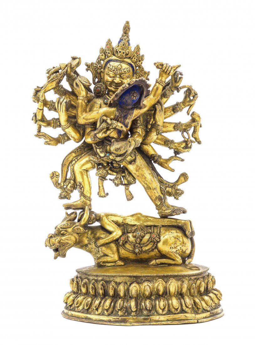 A Gilt Bronze Nepalese Figure of a Multi-Armed Deity in: A Gilt Bronze Nepalese Figure of a Multi-Armed Deity in Yabyum, with inlaid hardstones to his crown, the figures depicted standing on a figure laying on the back of a mythical beast, all raised on a d