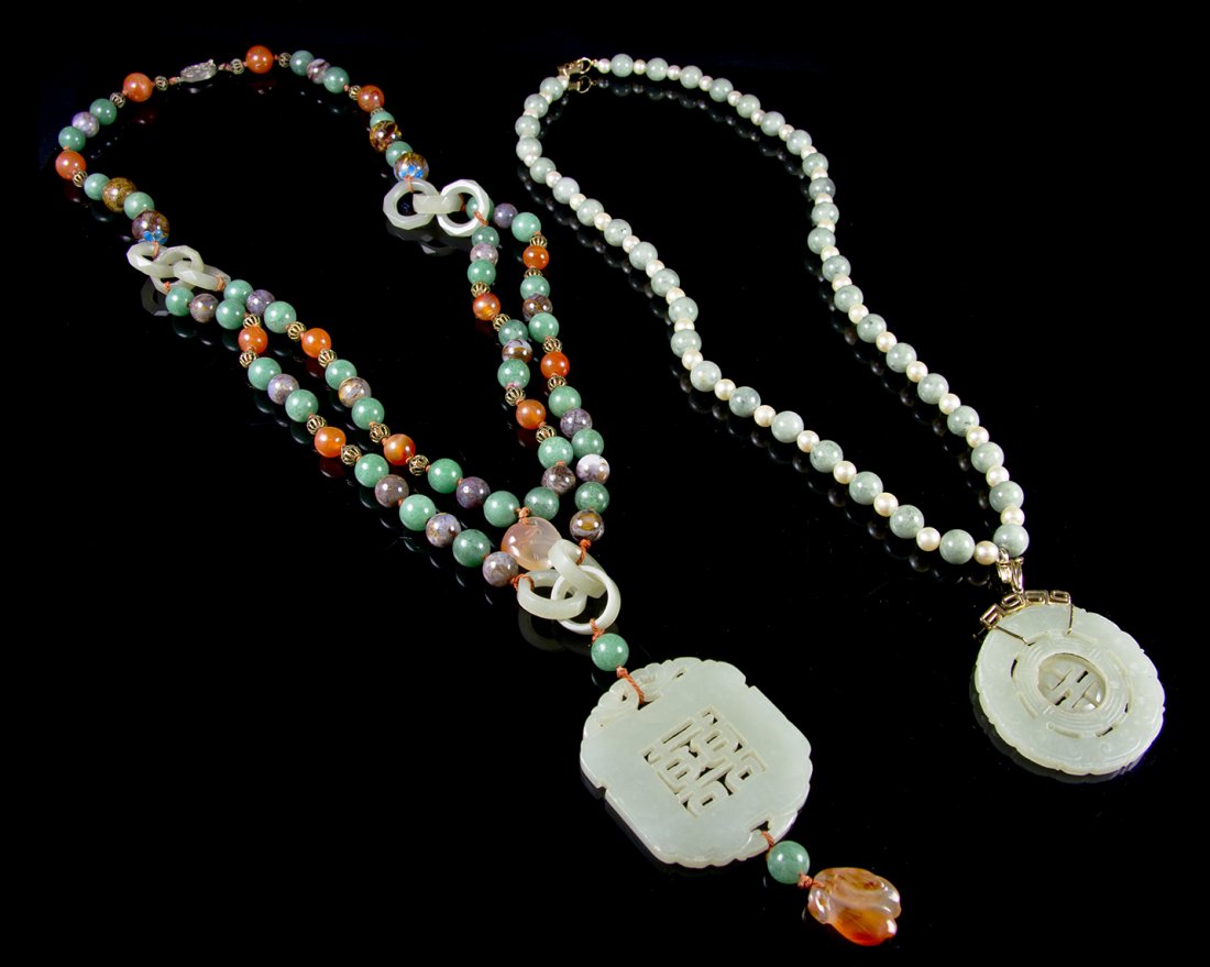 A Celadon Jade Shuangxi Pendant, Length of necklace: A Celadon Jade Shuangxi Pendant, mounted on a necklace with interlocking celadon rings and carnelian pendants, with a carved celadon pendant with moving center, mounted on a necklace. Length of neckla