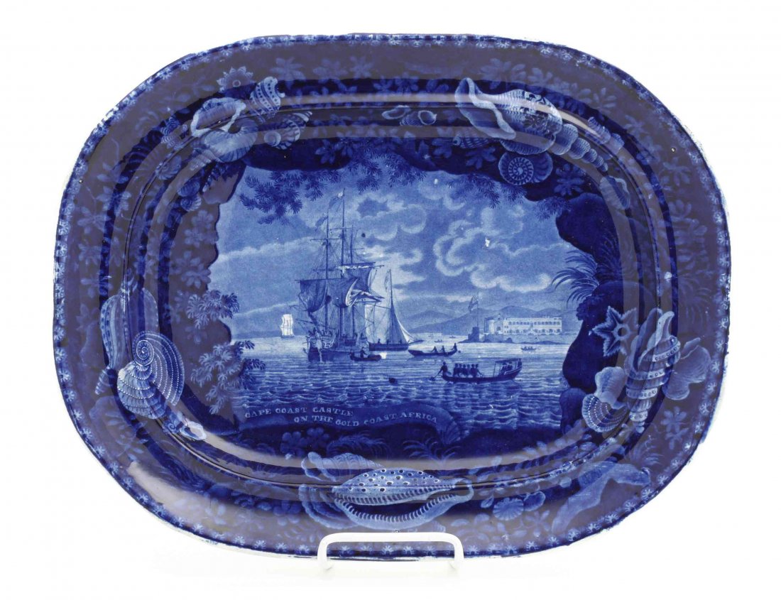 A Historical Blue Staffordshire Platter, Enoch Wood &: A Historical Blue Staffordshire Platter, Enoch Wood & Sons, depicting "Cape Coast Castle on the Gold Coast Africa", within a seashell and floral decorated border, the underside bearing an impressed En