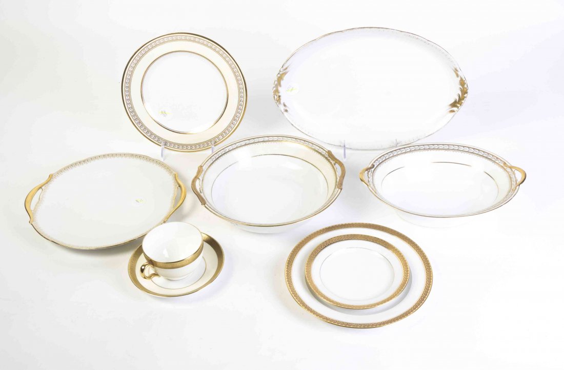 A Set of Twenty-Six Minton Teacups, Diameter of first 3: A Set of Twenty-Six Minton Teacups, each with gilt rim and handle, together with 26 saucers, 12 associated Limoges dinner plates, 15 bread plates, 12 salad plates and 5 serving articles. Diameter of f
