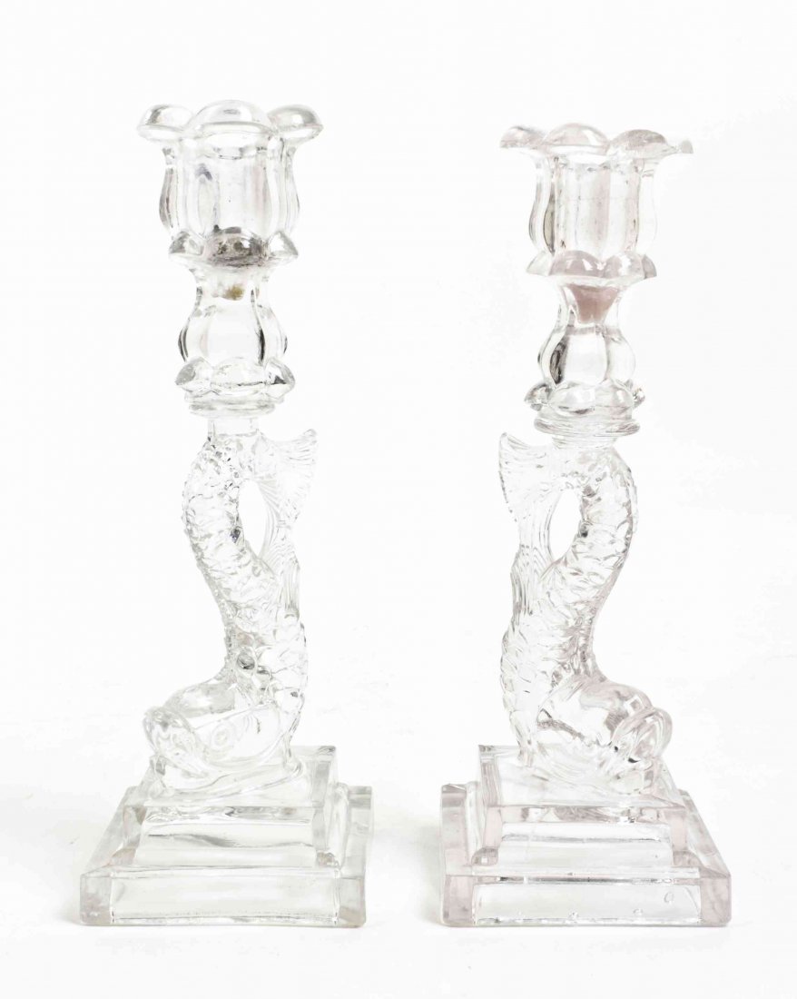 Two American Molded Glass Candlesticks, Height 10: Two American Molded Glass Candlesticks, each of dolphin form, raised on a rectangular base. Height 10 inches. Property from the Estate of Norman and Dorothy Holmes, Wilmette, Illinois