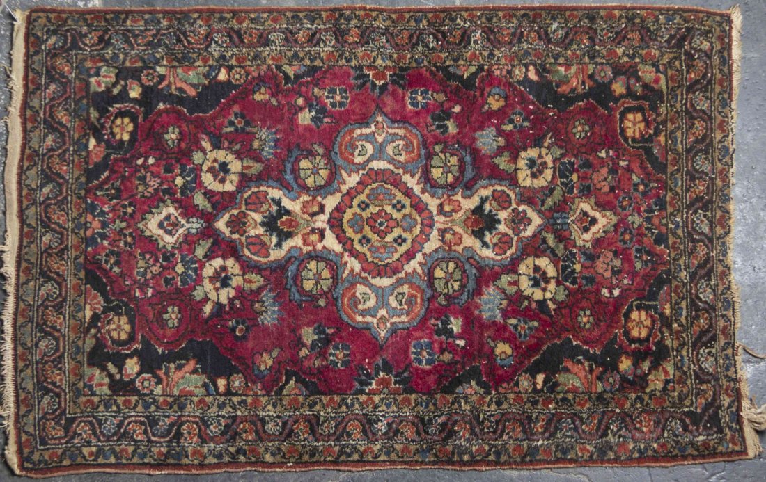 A Sarouk Wool Rug, 4 feet x 2 feet 8 inches.: A Sarouk Wool Rug, having a central cartouche form medallion on a maroon ground within multiple borders. 4 feet x 2 feet 8 inches.