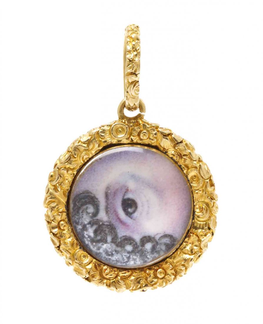 A Victorian Yellow Gold Lover's Eye Pendant, 5.40 dwts.: A Victorian Yellow Gold Lover's Eye Pendant, consisting of a central circular hand-painted plaque depicting a human eye with locks of black hair set within an intricate repousse foliate motif surround