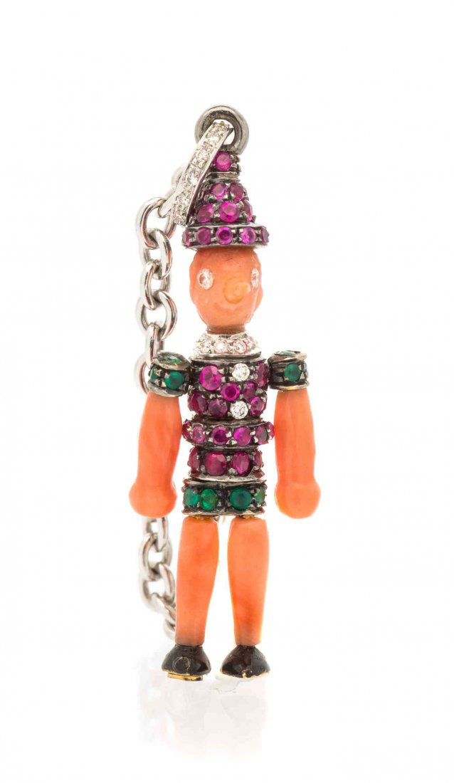 An 18 Karat White Gold, Carved Coral, Diamond, Ruby and: An 18 Karat White Gold, Carved Coral, Diamond, Ruby and Emerald Articulated Pinocchio Ring/Pendant, Michele della Valle, the head, nose, arms and legs composed of carved orange coral, the torso, upper