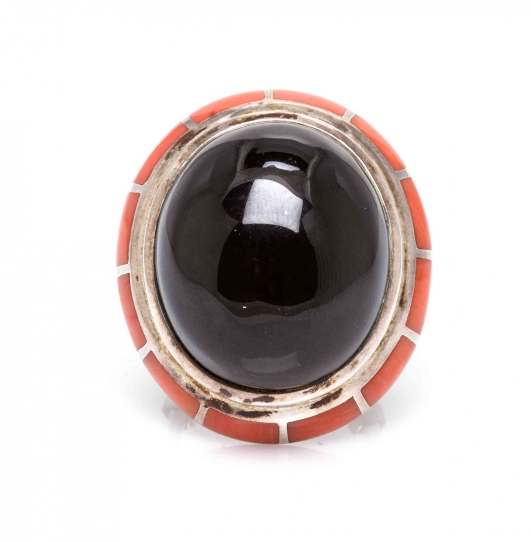 A Sterling Silver, Onyx and Coral Ring, Erte, 15.80: A Sterling Silver, Onyx and Coral Ring, Erte, containing one oval cabochon cut onyx measuring approximately 24.50 x 21.20 mm and 12 inlaid orange coral plaques. Stamp: (Erte maker's mark) 86/250 CFA S