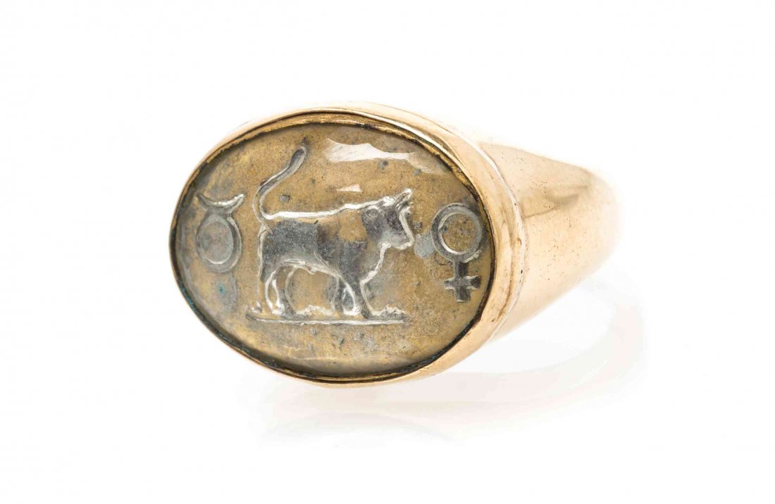 An Antique Yellow Gold and Essex Crystal Zodiac Symbol: An Antique Yellow Gold and Essex Crystal Zodiac Symbol Ring, the reverse intaglio crystal depicting symbols for Taurus. 10.30 dwts. Property from the Estate of Gerard L. Cafesjian, Naples, Florida