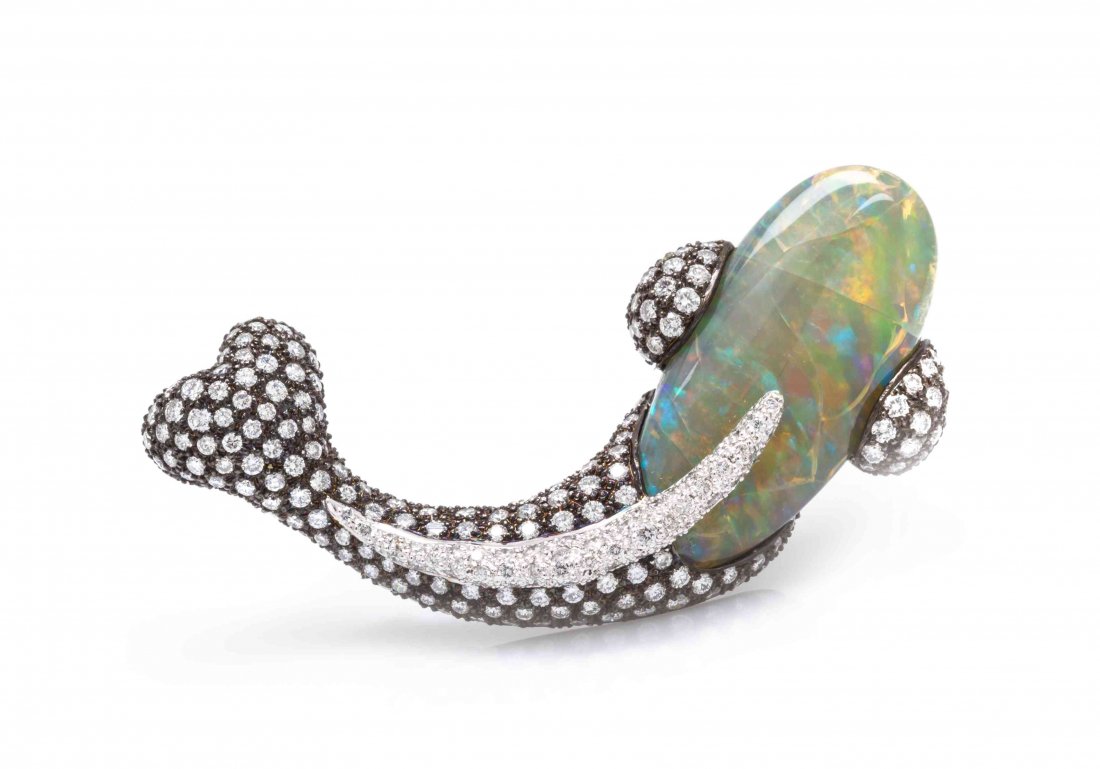 A Gold, Opal and Diamond Fish Brooch, Sifen Chang,: A Gold, Opal and Diamond Fish Brooch, Sifen Chang, consisting of a freeform cabochon cut crystal opal set within a black rhodium plated and white gold stylized fish motif setting pave set with numerou