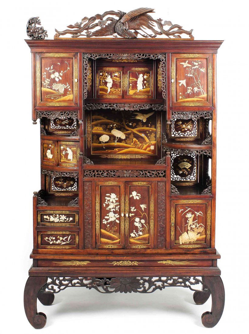 A Japanese Inlaid Shodana Cabinet, Height 83 1/2 x: A Japanese Inlaid Shodana Cabinet, having a pierce carved bird pediment, the multiple sliding and hinged doors having figural inlay in bone, ivory and abalone shell, having lacquered decoration and pi