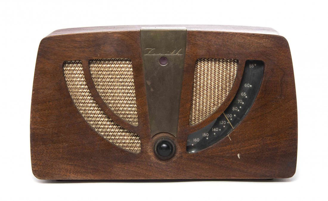 A Charles and Ray Eames Walnut Radio, American: A Charles and Ray Eames Walnut Radio, American (1907-1978), (1912-1988), for Zenith, the case of rectangular form with brass mounts, inset with fabric, model 6D030, with a paper label to base. Width 1