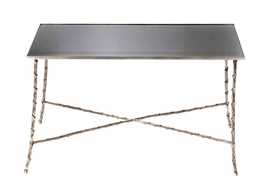 A Silvered Metal Low Table, in the manner of Maison: A Silvered Metal Low Table, in the manner of Maison Bagues, having a rectangular black glass inset top set on slightly splayed foliate cast legs, joined by conforming X-form stretchers, raised on sphe