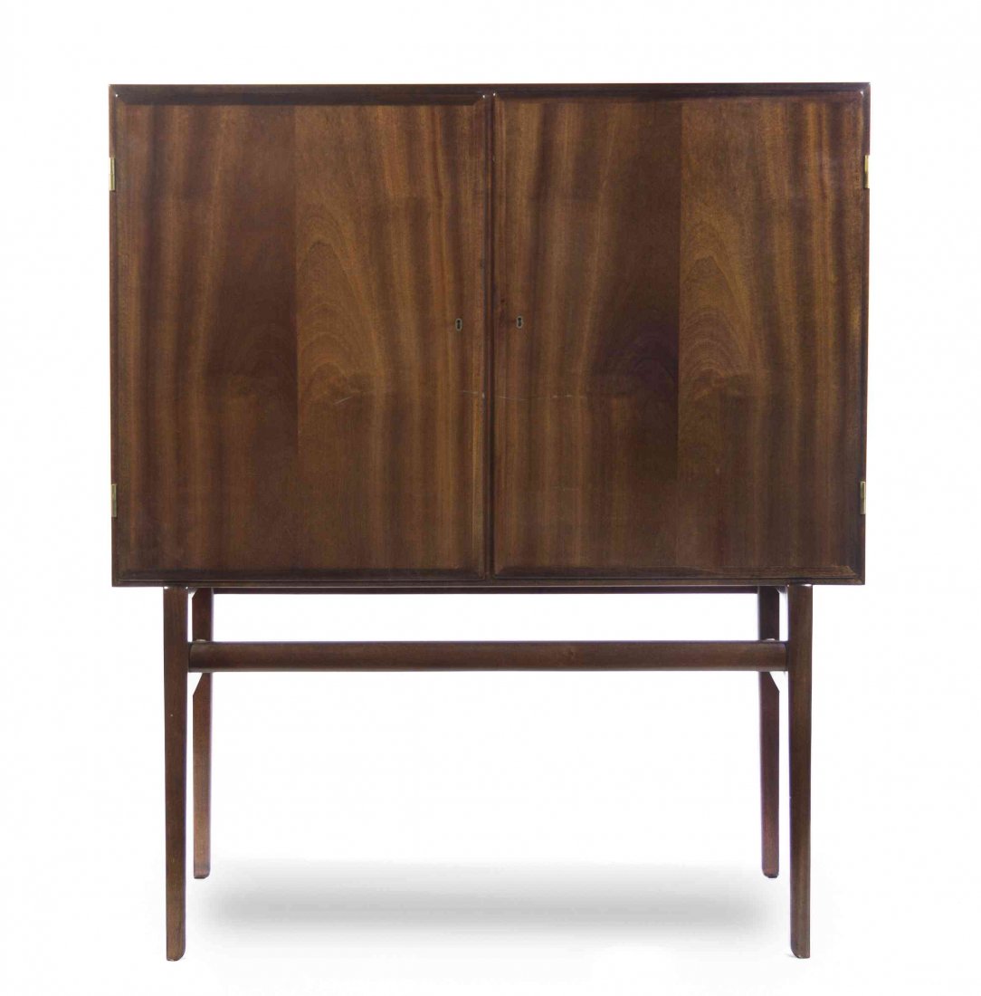 A Danish Mahogany Cabinet, Ole Wanscher (1903-1985),: A Danish Mahogany Cabinet, Ole Wanscher (1903-1985), having a rectangular top over two paneled doors, opening to a fitted interior, raised on cylindrical legs, joined by a stretcher, bearing Danish co