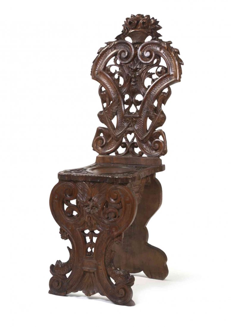 A Renaissance Revival Carved Mahogany Hall Chair,: A Renaissance Revival Carved Mahogany Hall Chair, having a pierce carved back showing a basket of flowers, a grotesque mask and stylized griffins over the plank seat, raised on scrolling supports carv