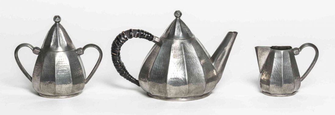 A French Art Deco Pewter Coffee Service, Alice: A French Art Deco Pewter Coffee Service, Alice (1872-1951) and Eugene (1872-1925) Chanal, comprising a coffee pot, a covered sugar and a creamer, each with hand hammered decoration, the coffee pot wit