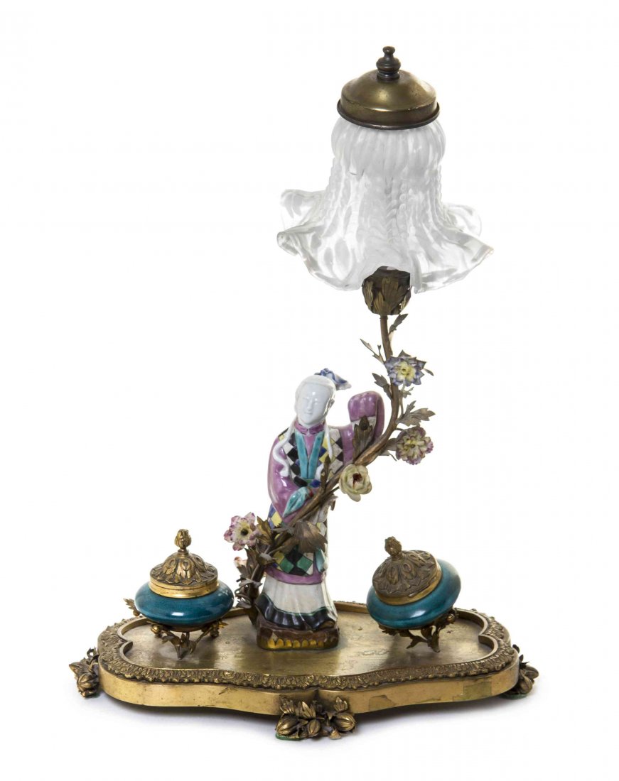 A Continental Porcelain Mounted Gilt Bronze Encrier,: A Continental Porcelain Mounted Gilt Bronze Encrier, mounted as a lamp with a Chinoiserie figure beneath a single lighting element with a glass shade, having two turquoise glazed porcelain ink pots. H