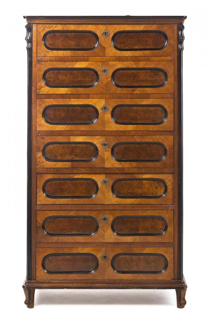 A Continental Parcel Ebonized Burlwood Semainier,: A Continental Parcel Ebonized Burlwood Semainier, having a molded cornice above seven aligned drawers flanked by fluted ebonized columns, raised on shaped feet. Height 63 1/4 x width 36 x depth 17 1/2
