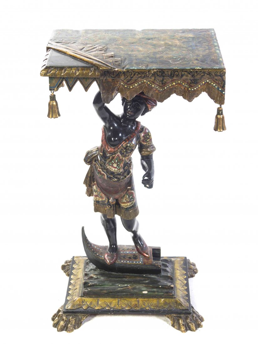 A Venetian Painted and Parcel Gilt Figural Console: A Venetian Painted and Parcel Gilt Figural Console Table, having a rectangular top carved with a draped valance and hung with tassel pendants, supported by a blackamoor with one arm raised and standin