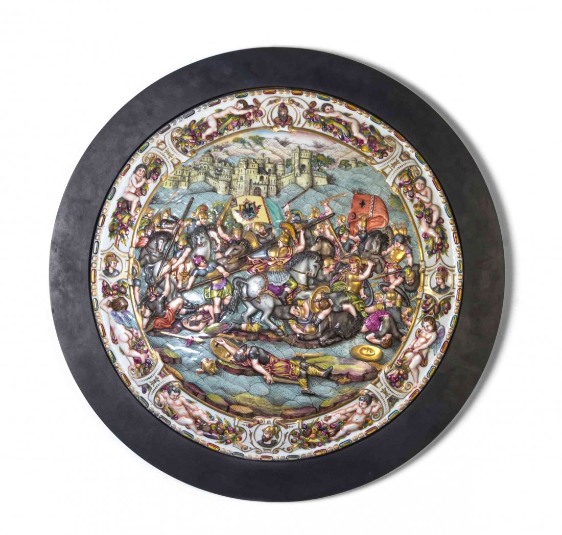 A Capodimonte Porcelain Charger, Diameter 21 inches.: A Capodimonte Porcelain Charger, of circular form depicting a battle scene within a continuous border of putti bearing fruit and floral garlands. Diameter 21 inches. Property from the Estate of a Prom