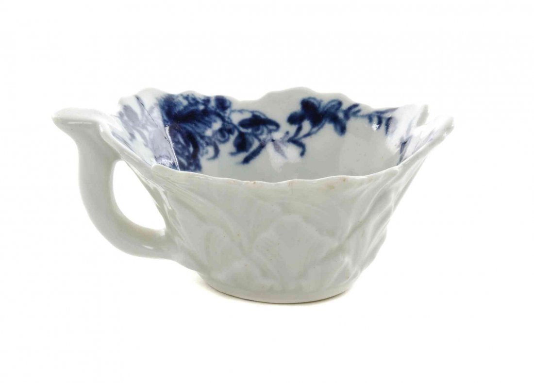 A Worcester Blue and White Porcelain Butter Boat, Width: A Worcester Blue and White Porcelain Butter Boat, CIRCA 1757, of foliate form, painted to show floral sprays and swags, bearing a blue workman's mark to the underside. Width 3 1/4 inches. Property fro
