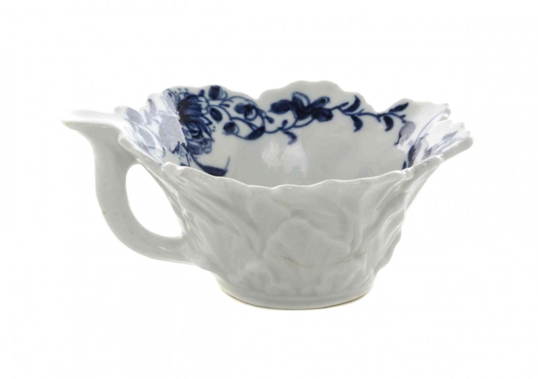 A Worcester Blue and White Porcelain Butter Boat, Width: A Worcester Blue and White Porcelain Butter Boat, CIRCA 1757, of foliate form, painted to show floral sprays and swags, bearing a blue workman's mark to the underside. Width 3 3/8 inches. Property fro