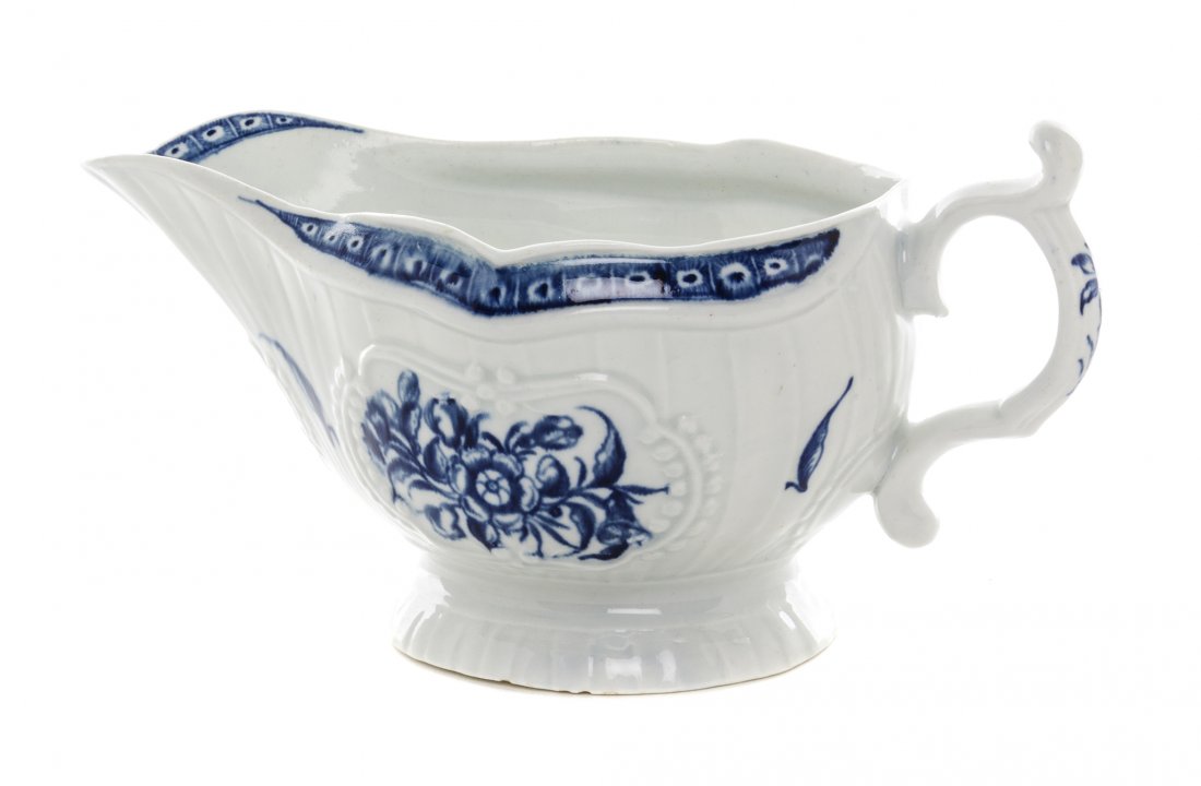 A Worcester Blue and White Porcelain Sauce Boat, Length: A Worcester Blue and White Porcelain Sauce Boat, CIRCA 1770, painted to show floral sprays, bearing a blue open crescent mark to the underside. Length over handles 8 inches. Property from the Collecti