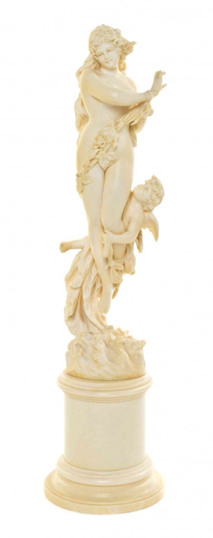 A Continental Art Nouveau Carved Ivory Figural Group,: A Continental Art Nouveau Carved Ivory Figural Group, depicting Venus and Cupid, raised on a pedestal base. Height overall 11 7/8 inches. Property from the Estate of Edsel and Dolores Safron, Town and